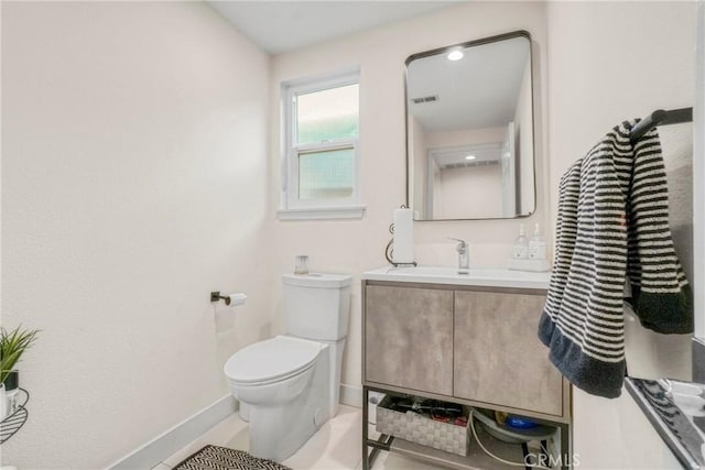 bathroom with tile patterned flooring, vanity, and toilet