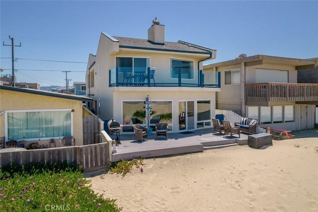 back of house with an outdoor living space, a balcony, and a deck