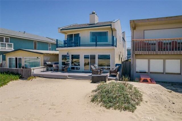 1652 Strand Way, Oceano, CA 93445 - back of house featuring an outdoor living space, stucco siding, a balcony, a chimney, and a patio area