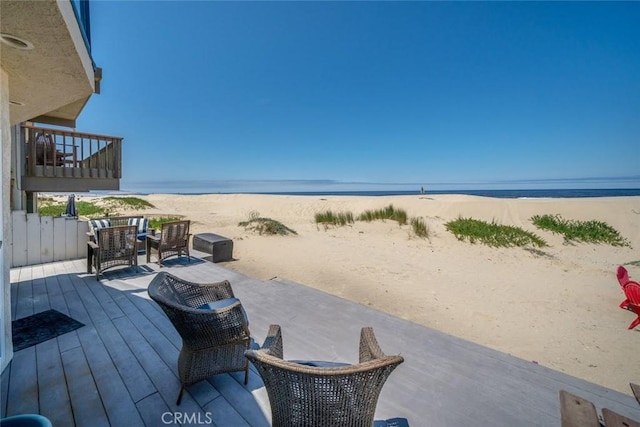 deck with a water view and a beach view