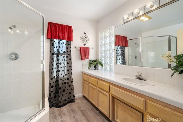 bathroom featuring wood-type flooring, vanity, and an enclosed shower