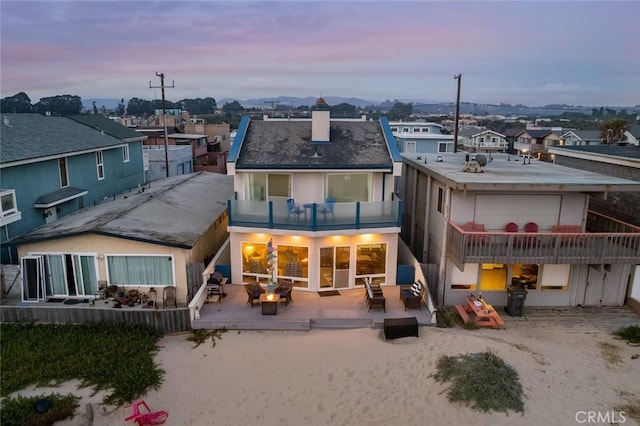 back house at dusk with a balcony