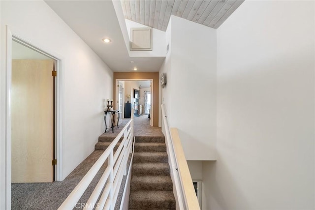 staircase with carpet floors, wooden ceiling, and lofted ceiling