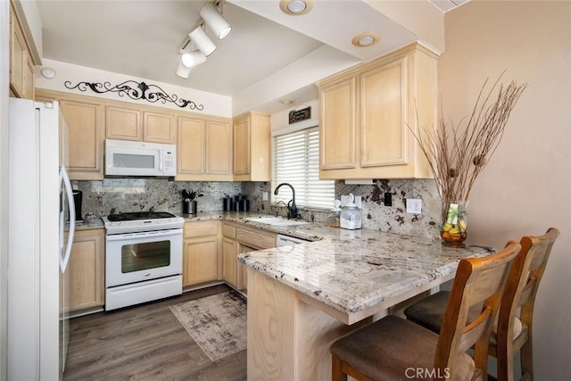 kitchen featuring kitchen peninsula, light brown cabinetry, tasteful backsplash, white appliances, and sink