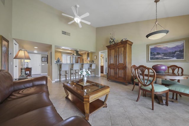 living room with light tile patterned floors, a towering ceiling, and ceiling fan