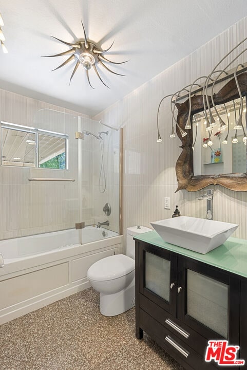 full bathroom featuring toilet, vanity, and tiled shower / bath