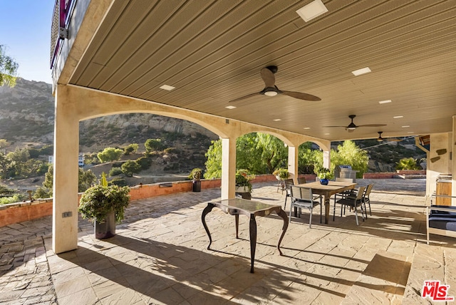 view of patio / terrace featuring ceiling fan and a mountain view