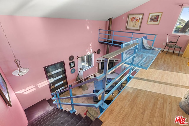 stairs with hardwood / wood-style flooring and lofted ceiling