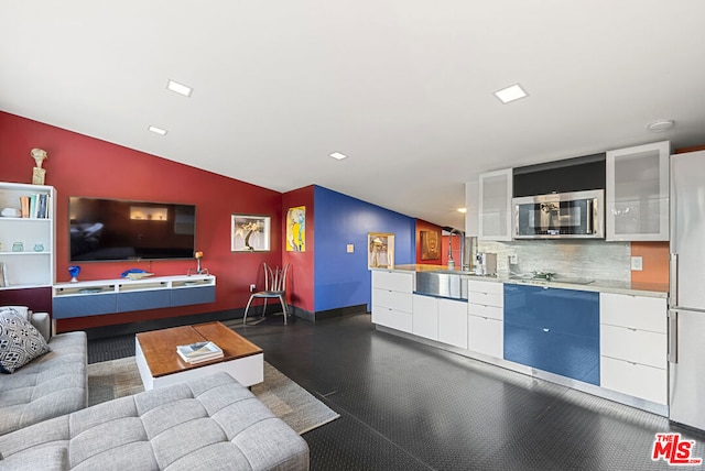 living room featuring lofted ceiling and sink