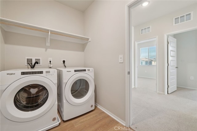 laundry area with washing machine and dryer and light carpet