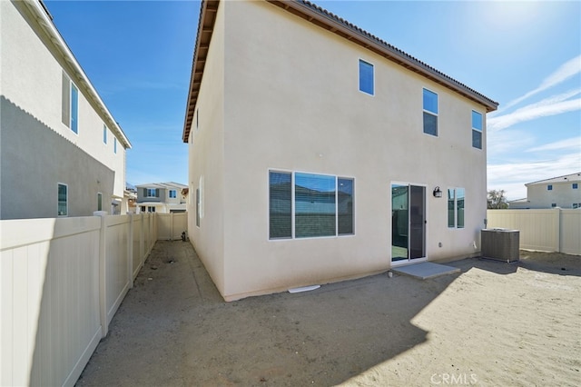 rear view of property featuring a patio and central air condition unit