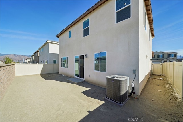 rear view of property featuring a mountain view, central AC, and a patio area