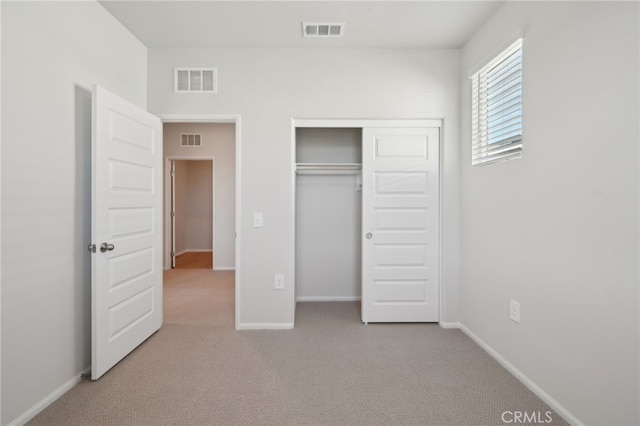 unfurnished bedroom with a closet and light carpet