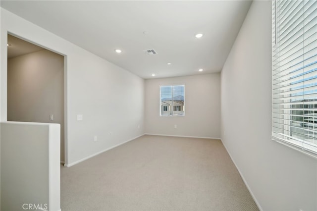 unfurnished room featuring light carpet