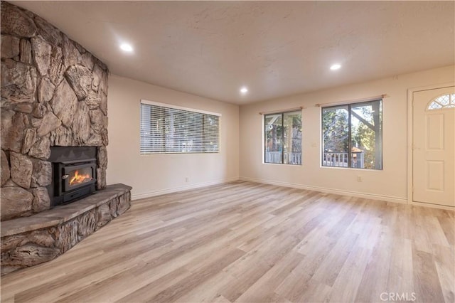 unfurnished living room with a fireplace and light wood-type flooring