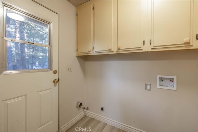 washroom with washer hookup, gas dryer hookup, cabinets, and light wood-type flooring