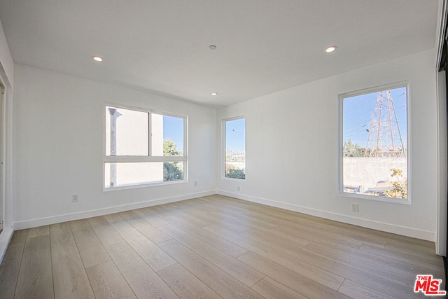 unfurnished room with plenty of natural light and light hardwood / wood-style floors