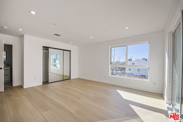 unfurnished bedroom featuring a closet and light hardwood / wood-style flooring