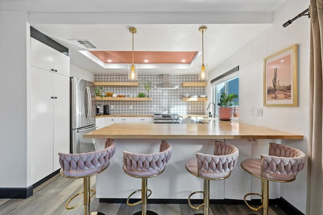 kitchen featuring a breakfast bar, kitchen peninsula, and decorative light fixtures