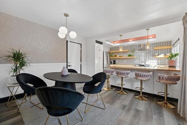 dining space with a tray ceiling and wood-type flooring