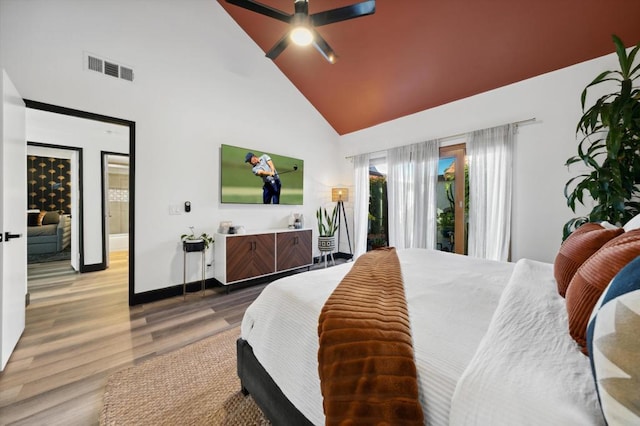 bedroom with connected bathroom, access to exterior, ceiling fan, high vaulted ceiling, and wood-type flooring