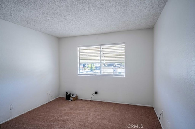 empty room with a textured ceiling and carpet flooring