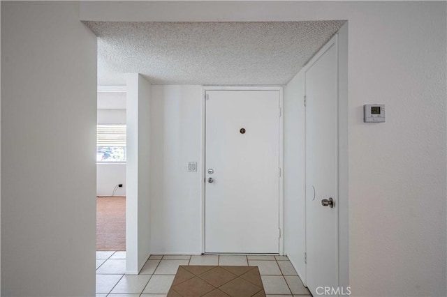 interior space featuring a textured ceiling and light tile patterned floors