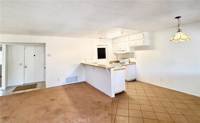 kitchen with white cabinets, hanging light fixtures, white range with gas cooktop, light colored carpet, and kitchen peninsula