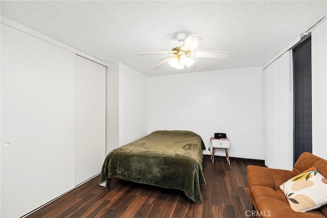 bedroom with a closet, ceiling fan, dark hardwood / wood-style flooring, and a textured ceiling