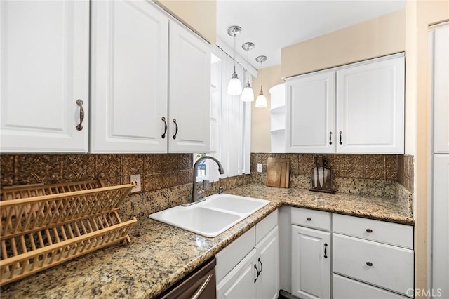 kitchen featuring sink, pendant lighting, stone countertops, decorative backsplash, and white cabinets