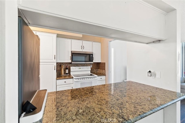 kitchen with kitchen peninsula, tasteful backsplash, dark stone counters, stainless steel appliances, and white cabinets