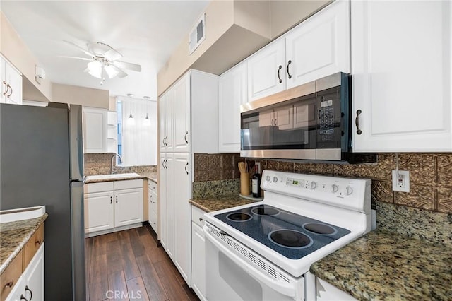 kitchen with dark hardwood / wood-style flooring, tasteful backsplash, dark stone counters, stainless steel appliances, and white cabinetry