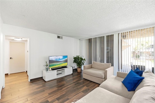 living room with dark hardwood / wood-style flooring and a textured ceiling