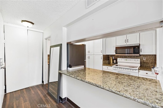 kitchen with dark hardwood / wood-style flooring, light stone counters, a textured ceiling, stainless steel appliances, and white cabinets