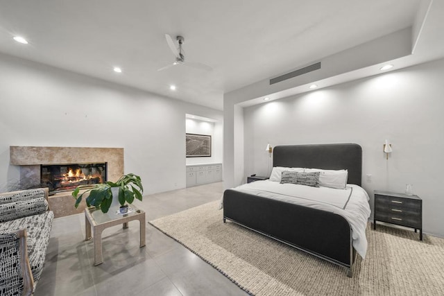 bedroom featuring ceiling fan and a fireplace