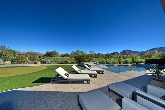 view of swimming pool with a patio area and a mountain view