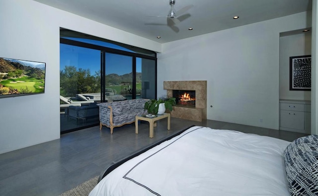 bedroom featuring a fireplace and ceiling fan