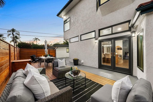 patio terrace at dusk featuring an outdoor living space and french doors