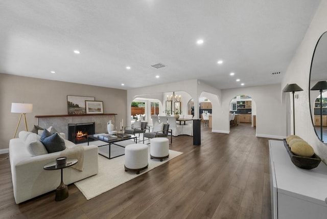 living room with dark wood-type flooring and a tiled fireplace