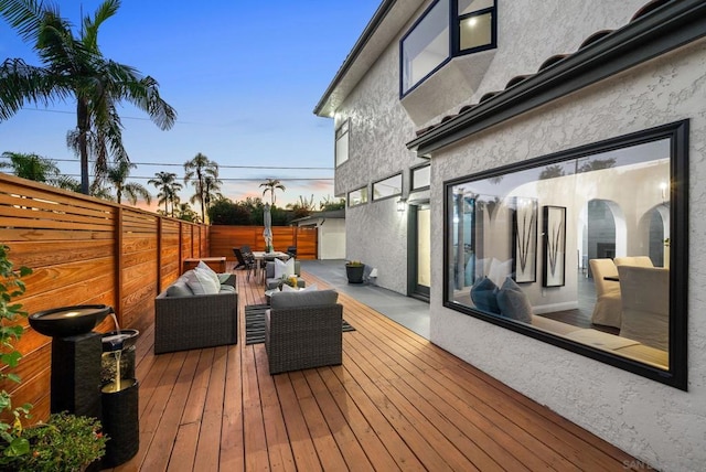 deck at dusk with an outdoor living space