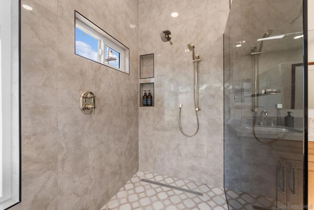 bathroom featuring sink and a tile shower