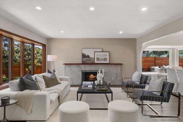 living room featuring a tiled fireplace and light hardwood / wood-style floors