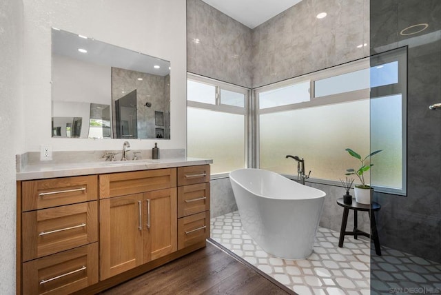 bathroom featuring vanity, wood-type flooring, plenty of natural light, and independent shower and bath