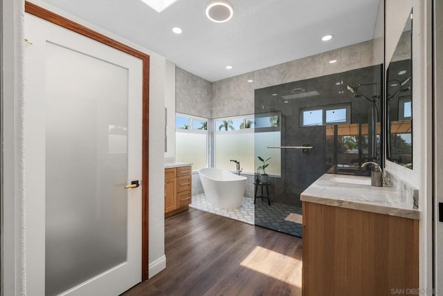 bathroom featuring hardwood / wood-style flooring, vanity, and plus walk in shower