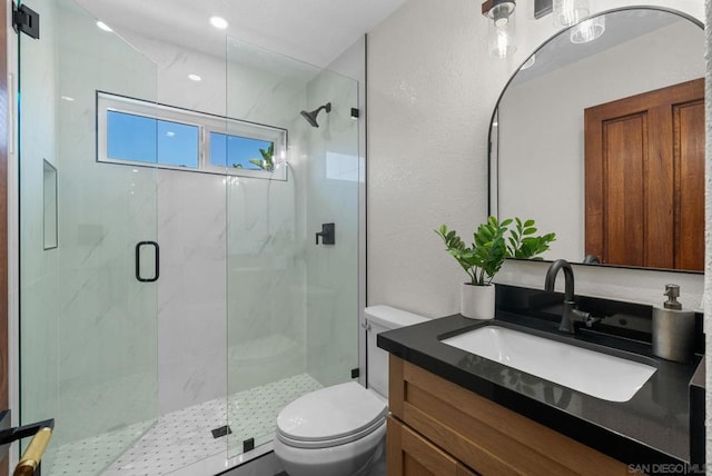 bathroom with toilet, an enclosed shower, and vanity