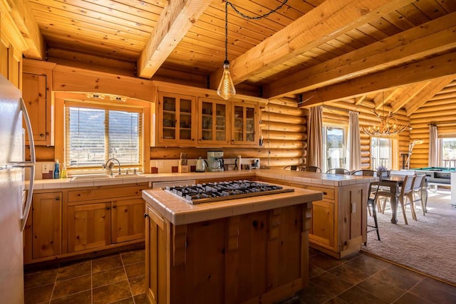 kitchen featuring tile counters, a kitchen island, plenty of natural light, and sink