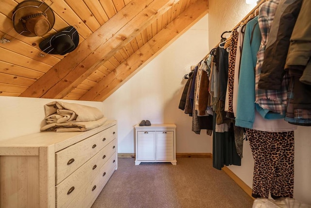 walk in closet featuring vaulted ceiling with beams and dark carpet