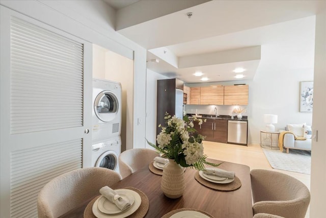 dining area featuring stacked washer / drying machine and sink