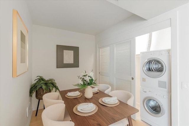 dining area featuring stacked washer / dryer and light hardwood / wood-style flooring