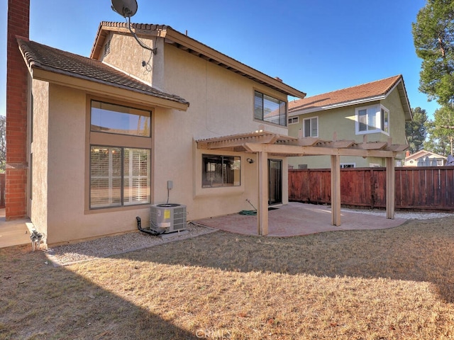 back of house featuring central AC, a pergola, a patio area, and a yard